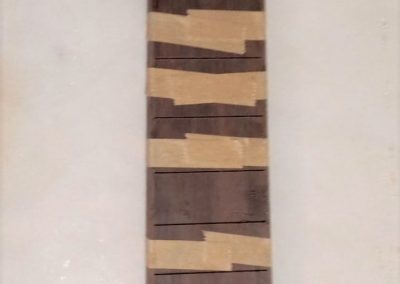 Brazillian binding has been glued on to the fretboard for blind frets